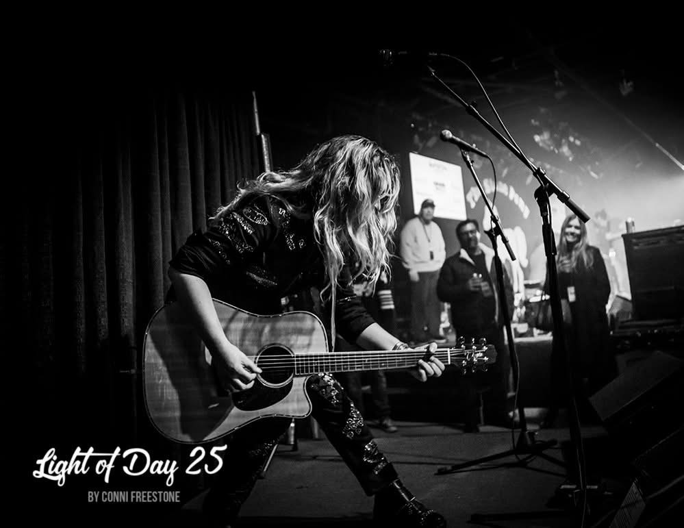 Alexandra Jardvall spelar akustisk gitarr på scen under Light of Day WinterFest 2025.
